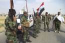 Iraqi Shi'ite militia fighters gather outside Bo Hassan village near Tikrit