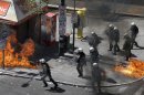 A fire bomb explodes among riot police during clashes in Athens Wednesday Sept. 26, 2012. Police clashed with protesters hurling petrol bombs and bottles in central Athens Wednesday after an anti-government rally called as part of a general strike in Greece turned violent. (AP Photo/Dimitri Messinis)