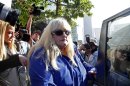 In this Wednesday, Aug. 14, 2013 file photo, Debbie Rowe, Michael Jackson's former wife and mother of two of his children, leaves Los Angeles County Superior Court after testifying in the negligence lawsuit filed by Jackson's mother, Katherine Jackson, against AEG Live, in Los Angeles. Rowe told a Los Angeles jury on Thursday, Aug. 15, 2013, that injuries and medical conditions left the singer feeling disfigured and forced him to wear wigs and de-pigment his skin. These difficult treatments she said were made harder by Jackson's superstar status. (AP Photo/Nick Ut, File)