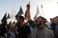Libyan followers of the Ansar al-Shariah Brigades chant anti-U.S. slogans during a protest in front of the Tibesti Hotel, in Benghazi, Libya, Friday, Sept. 14, 2012, as part of widespread anger across the Muslim world about a film ridiculing Islam's Prophet Muhammad. One of the leading suspects in an attack that killed the U.S. ambassador and three other Americans is the Libyan-based Islamic militant group Ansar al-Shariah, led by former Guantanamo detainee Sufyan bin Qumu. The group denied responsibility in a video Friday but did acknowledge its fighters were in the area during what it called a “popular protest” at the consulate, according to Ben Venzke of the IntelCenter, a private analysis firm that monitors Jihadist media for the U.S. intelligence community. (AP Photo/Mohammad Hannon)