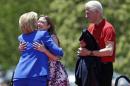 Chelsea Clinton, center, hugs democratic presidential candidate, former Secretary of State Hillary Rodham Clinton, as former President Bill Clinton, right, watches them Saturday, June 13, 2015, on Roosevelt Island in New York. (AP Photo/Frank Franklin II)