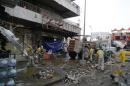 Municipal workers clean up the site of a car bomb attack in Baghdad's Karaada district