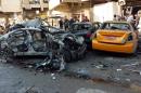 Iraqis inspect the aftermath of a car bomb explosion in Baghdad's eastern neighbourhood of al-Jadidah on January 20, 2014