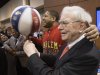 Berkshire Hathaway Chairman and CEO Warren Buffett, right, is watched by Detroit Lions defensive tackle Ndamukong Suh, left, as he is assisted by Harlem Globetrotter Chris “Handles” Franklin in spinning a basketball in Omaha, Neb., Saturday, May 4, 2013, before holding the Berkshire Hathaway shareholders meeting. Tens of thousands attend Berkshire Hathaway shareholder meeting to hear Warren Buffett and Charlie Munger answer questions for more than six hours. No other annual meeting can rival Berkshire's, which is known for its size, the straight talk Buffett and Munger offer and the sales records shareholders set while buying Berkshire products. (AP Photo/Nati Harnik)
