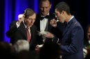 David H. Petraeus, former army general and head of the Central Intelligence Agency, tastes a ceremonial cake presented to him by Hector Sandoval, a member of the USC ROTC program, at the annual dinner for veterans and ROTC students at the Univeristy of Southern California, in downtown Los Angeles Tuesday, March 26, 2013. It marked Petraeus' first public remarks since he retired as head of the CIA after an extramarital affair scandal. (AP Photo/Reed Saxon)