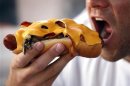 A man takes a bite from a hot dog in Hollywood