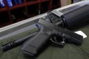 A Glock 22 pistol is seen laying on a Palmetto M4 assault rifle at the Rocky Mountain Guns and Ammo store in Parker, Colorado