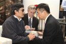 File handout photo from U.S. Embassy Beijing Press office shows U.S. Ambassador to China Gary Locke holding blind activist Chen Guangcheng's hands as they talk in Beijing