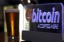 A beer poured for a customer sits on a bar next to a Bitcoin sign in central Sydney, Australia