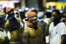 Young men wait to see to see what happens during another night of demonstrating in Ferguson