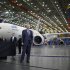 Boeing CEO Jim McNerney waits to be introduced to speak, in front of a Boeing 787 Dreamliner under construction in Everett