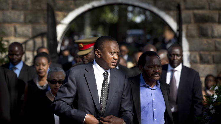 FILE - In this Friday, Sept. 27, 2013 file photo, Kenya's President Uhuru Kenyatta, center-left, arrives for the burial ceremony of his nephew Mbugua Mwangi and Mwangi's fiancee Rosemary Wahito, who were both killed in the Westgate Mall terrorist attack, at the burial site in the village of Ichawara, Kenya. A new poll released Thursday, Nov. 14, 2013 by Ipsos Synovate says two out of three people in Kenya want to see their president report to the International Criminal Court to respond to charges of crimes against humanity. (AP Photo/Ben Curtis, File)