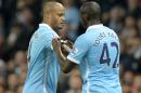 Manchester City's defender Vincent Kompany (L) receives the captain's armband from midfielder Yaya Toure as he comes on as a substitute on December 26, 2015