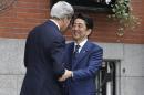 Secretary of State John Kerry, left, greets Japanese Prime Minister Shinzo Abe in front of Kerry's residence in the Beacon Hill neighborhood of Boston, Sunday, April 26, 2015. Abe arrived in the U.S. Sunday for a weeklong visit. (AP Photo/Steven Senne)