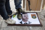 Syrian rebels stand on a picture of President Bashar al-Assad in Aleppo last week. Assad said on Sunday that Syria will defeat what he described as a foreign plot being waged against the country, according to the official SANA news agency. (AFP Photo/Achilleas Zavallis)