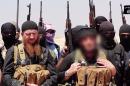 An image released by jihadist outlet al-Itisam Media on June 29, 2014, is said to shows Islamic State members including Abu Mohammed al-Adnani (right), whose picture was blurred by the source to protect his identity, speaking at an unknown location