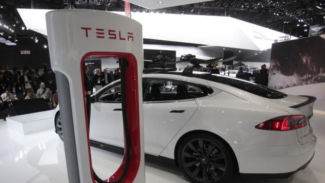 A Tesla S electric car and a charging station are displayed during the press preview day of the North American International Auto Show in Detroit