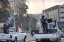 Members of the Free Syrian Army fire weapons mounted on a pick-up truck in Deir al-Zor