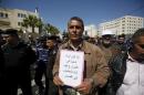 Palestinian teacher holds a sign during a protest demanding better pay and conditions, in the West Bank city of Ramallah