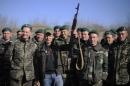 In this photo taken on Saturday, April 5, 2014, Oleh Lyashko, center left, leader of Ukrainian Radical Party and presidential candidate who supported the protests that ousted Russian-leaning president Viktor Yanukovych, poses with Ukrainian soldiers and officers at their camp near Ukraine-Russian border outside Chernihiv, 140km (87 miles) northeast of Kiev, Ukraine. Ukraine's security service said Saturday it has detained a 15-strong armed gang planning to seize power in an eastern province on the border with Russia. (AP Photo/Osman Karimov)