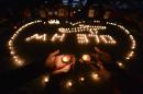 In this March 13, 2014 file photo, university students hold a candlelight vigil for passengers on the missing Malaysia Airlines Flight MH370 in Yangzhou, in eastern China's Jiangsu province. The disappearance of Malaysia Airlines Flight 370 has exposed wide gaps in how the world's airlines, and their regulators, operate. But experts warn this isn't likely to be one of those defining moments that lead to fundamental changes. (AP Photo/File) CHINA OUT