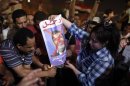 Protesters light a poster of President Mohamed Mursi on fire in Tahrir square, Cairo