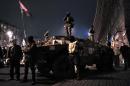 Maidan self-defence activists stand on an armoured vehicle in central Kiev, on February 23, 2014