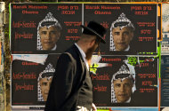FILE -- In this Sunday, June 14, 2009 file photo, an Ultra Orthodox Jewish man walks past posters depicting US President Barack Obama wearing a traditional Arab headdress, in Jerusalem, Sunday, June 14, 2009. President Barack Obama’s vow to take his message straight to the public during his first presidential visit to Israel next week will be a tough sell with many Israelis who consider him naive, too soft on the nation’s enemies and even hostile to Prime Minister Benjamin Netanyahu. (AP Photo/Sebastian Scheiner, File)