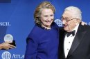 Clinton smiles as Kissinger presents her with a Distinguished Leadership Award from the Atlantic Council in Washington