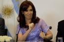 Argentina's President Cristina Fernandez, sitting in a wheelchair, cheers at supporters at the Casa Rosada government palace during a signing ceremony in Buenos Aires, Argentina, Friday, Jan. 30, 2015. Fernandez said Friday that she will voice all the opinions she wants to about the case of prosecutor Alberto Nisman, who was found dead on Jan. 18, hours before he was to elaborate on his accusation that Fernandez protected those responsible for a 1994 terror bombing. (AP Photo/Rodrigo Abd)