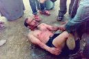 This image made from video, which has been authenticated based on its contents and other AP reporting shows a man, bound by his feet, surrounded by villagers as he asks to be taken to a hospital, before he was beaten and then tied to a tree until he died in the northern Sharqiya province in Egypt, Thursday, March 21, 2013. Egyptian witnesses and officials say villagers beat the man to death after catching him trying to steal a car in a new case of vigilante violence. A number of recent lynchings or attempted lynchings have raised worries over an increasing breakdown of security, adding a new challenge to Egypt's government. A security official says dozens of villagers in Ezbat el-Gindy in the northern Sharqiya province caught the man trying to steal a car at gunpoint Thursday.(AP Photo)