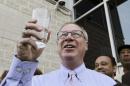 Toledo Mayor D. Michael Collins raises a glass of tap water before drinking it during a news conference in Toledo, Ohio, Monday, Aug. 4, 2014. A water ban that had hundreds of thousands of people in Ohio and Michigan scrambling for drinking water has been lifted, Collins announced Monday. (AP Photo/Paul Sancya)