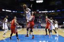 Russell Westbrook (0) del Thunder de Oklahoma City tira a la canasta ante Omer Asik (3) de los Rockets de Houston en la serie de playoffs de la NBA el miércoles 24 de abril de 2013. (AP Foto/Sue Ogrocki)