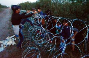 Migrants from several countries jump over a razor-wire&nbsp;&hellip;
