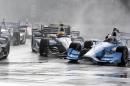 James Jakes of England, center, slides into Tony Kanaan of Brazil on the first turn during the first race of the IndyCar Detroit Grand Prix auto racing doubleheader Saturday, May 30, 2015, in Detroit. Colombian Carlos Munoz won the rain shortened race. (AP Photo/Carlos Osorio)
