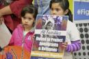 Jocelynn Lujan, 6, left, and her sister, Jennifer, 8, attend a news conference in Albuquerque, N.M., Wednesday, Jan. 25, 2017, where activists denounced President Donald Trump's executive actions on immigration. Many U.S. Muslim and Latino advocates have been speaking out and preparing lawsuits against executive actions taken by President Donald Trump to build a Mexican border wall and strip funding for immigrant protecting sanctuary cities, as well as anticipated orders to restrict refugees. (AP Photo/Russell Contreras)