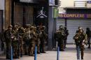 French army soldiers stand in position in the northern Paris suburb of Saint-Denis city center, on November 18, 2015, as French Police special forces raid an apartment, hunting those behind the attacks that claimed 129 lives in the French capital