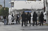 Peritos forenses realizan el levantamiento de uno de los cinco jóvenes asesinados por un grupo de presuntos sicarios hoy, martes 1 de noviembre de 2011, en un barrio popular de Monterrey (México). EFE/STR