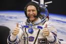 FILE - In this Tuesday, Dec. 15, 2015 file photo, British astronaut Tim Peake, member of the main crew of the expedition to the International Space Station (ISS), gestures prior the launch of Soyuz TMA-19M space ship at the Russian leased Baikonur cosmodrome, Kazakhstan. Anyone can dial a wrong number, but it's not often done from outer space. Peake tweeted an apology on Christmas Day from the International Space Station after calling a wrong number. (AP Photo/Dmitry Lovetsky, File)