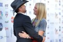 Musician Tim McGraw, left, embraces actress Gwyneth Paltrow at "Stand Up to Cancer" at the Shrine Auditorium on Friday, Sept. 7, 2012 in Los Angeles. The initiative aimed to raise funds to accelerate innovative cancer research by bringing new therapies to patients quickly. McGraw and Paltrow starred as a married couple in the film "Country Strong." Paltrow's father Bruce died from cancer in 2002. (Photo by John Shearer/Invision/AP)