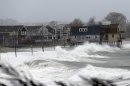 Ocean waves kick up near homes along Peggoty Beach in Scituate, Mass. Monday, Oct. 29, 2012. Hurricane Sandy continued on its path Monday, as the storm forced the shutdown of mass transit, schools and financial markets, sending coastal residents fleeing, and threatening a dangerous mix of high winds and soaking rain. (AP Photo/Elise Amendola)