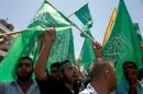 Palestinians hold flags of the Hamas movement during a demonstration in support of Palestinian prisoners ron May 30, 2014 in the Deheisheh refugee camp