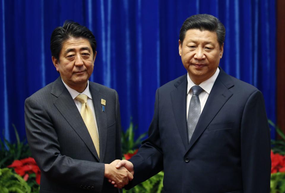 FILE - In this Nov. 10, 2014, file photo, Japan&#39;s Prime Minister Shinzo Abe, left, and China&#39;s President Xi Jinping, right, shake hands during...