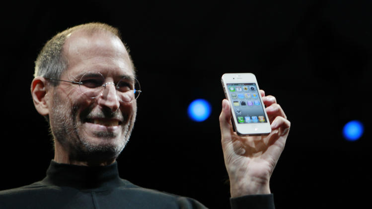 FILE - In this June 7, 2010, file photo, Apple CEO Steve Jobs smiles with a new iPhone at the Apple Worldwide Developers Conference in San Francisco. In the white-hot competition for tech talent, some workers are alleging Silicon Valley's top companies conspired to keep employees from switching teams. A federal class-action suit claims that senior executives at Google, Intel, Adobe, Intuit, Lucasfilm, Pixar and Apple entered into secret anti-poaching agreements not to hire each other's best workers. And plaintiffs say e-mails uncovered during a U.S. Justice Department investigation put Steve Jobs at the center of the alleged conspiracy of so-called "gentlemen's agreements." The defendants say there was no conspiring, just one-to-one pacts between individual companies in the course of doing business and collaborating on innovative products. Apple is seeking to have the case thrown out. (AP Photo/Paul Sakuma, File)
