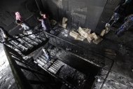 Members of the police inspect the burnt interior of a garment factory after a fire in Savar November 25, 2012. REUTERS/Andrew Biraj