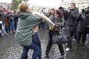 An activist from women's rights protest group Femen is restrained by a policewoman as a woman tries to hit her with an umbrella in Saint Peter's Square at the Vatican