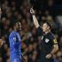 Chelsea's John Mikel is shown a yellow card by referee Clattenburg during their English Premier league soccer match against Manchester United in London