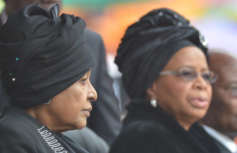 Winnie Madikizela–Mandela (L) and widow Graca Machel attend the memorial service for late South African President Nelson Mandela at Soccer City Stadium in Johannesburg on December 10, 2013