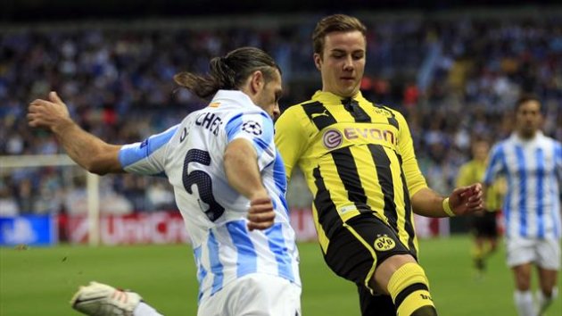 Malaga's Martin Demichelis (L) fights for the ball with Borussia Dortmund's Mario Gotze during their Champions League quarter final first leg match at La Rosaleda