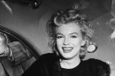 FILE - In this June 2, unknown year, file photo, actress Marilyn Monroe smiles in a car after arriving tousled from an all-night plane flight from Hollywood to Idlewild Airport, in New York. The actress said she planned to rest in New York before going to England to make a new movie with Sir Laurence Olivier. In late 2012, the FBI has released a new version of files it kept on Monroe that reveal the names of some of her acquaintances who had drawn concern from government officials and members of her entourage over their suspected ties to communism. (AP Photo, File)